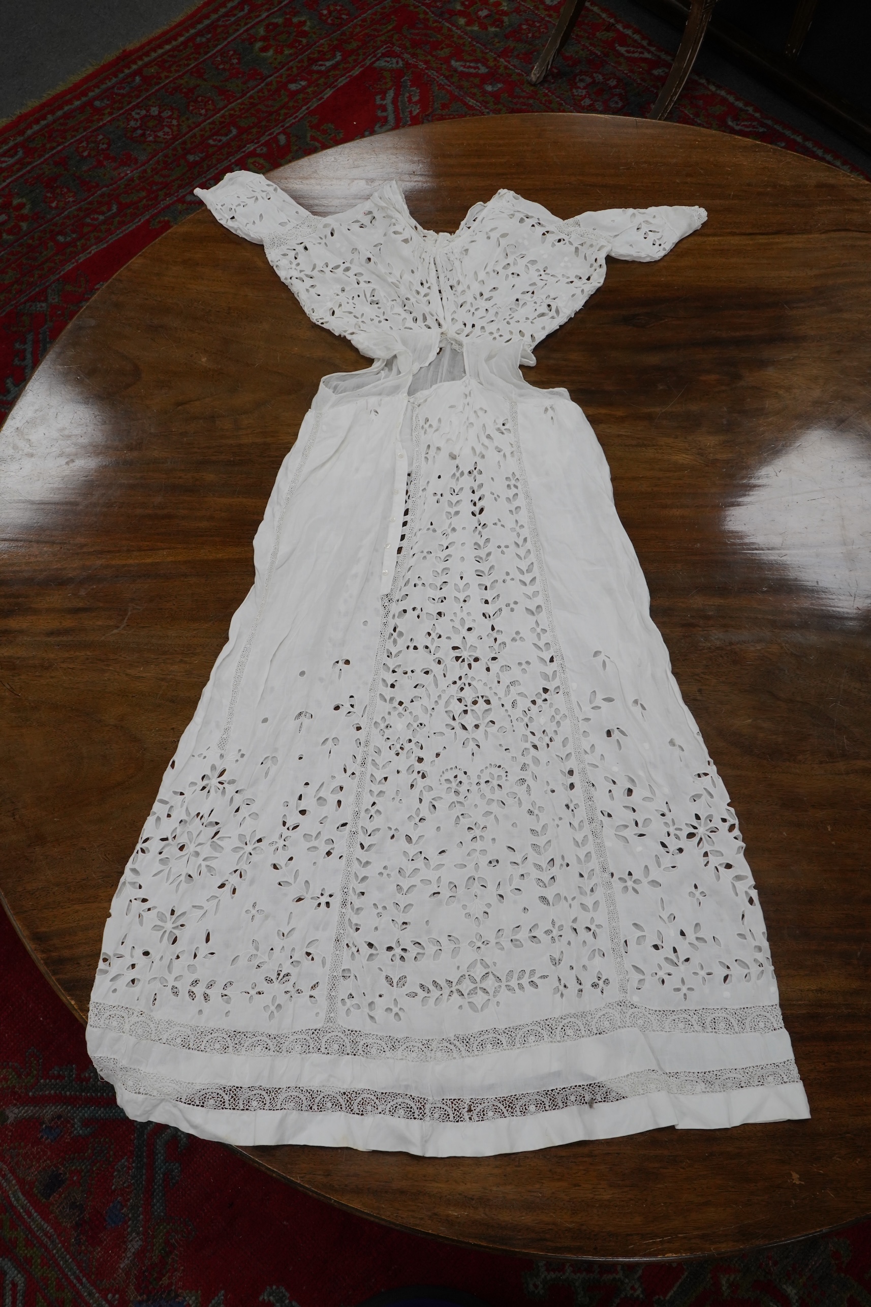 An Edwardian fine white embroidery anglaise and Irish crochet trimmed ladies summer dress, designed with large panels of anglaise cut work, the dress has been altered and restyled, which could be altered back, 134cm long